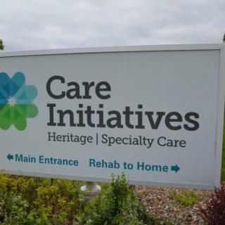 Sign for Care Initiatives, indicating main entrance and rehab to home services.