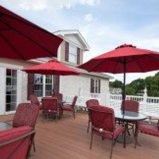 A spacious outdoor patio with red umbrellas and furniture on a deck.