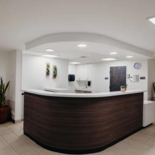 A modern office reception area with a sleek desk and minimalist design.