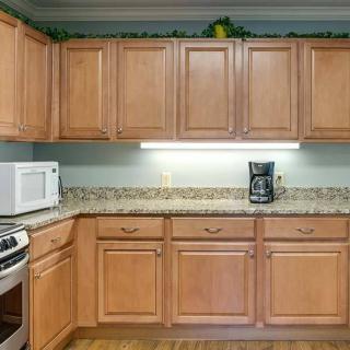 A modern kitchen with wooden cabinets and appliances.