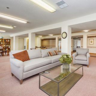 A spacious living room with a modern sofa and glass coffee table.
