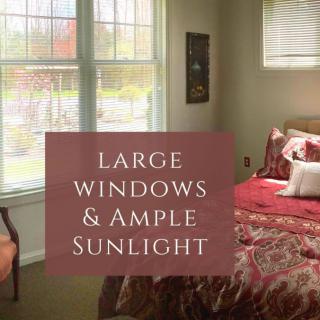 A cozy bedroom featuring large windows that allow plenty of natural sunlight.