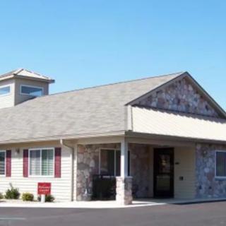A small building with a stone facade and a pitched roof under a clear blue sky.
