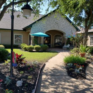 A picturesque house with a well-maintained garden and a pathway leading to the entrance.
