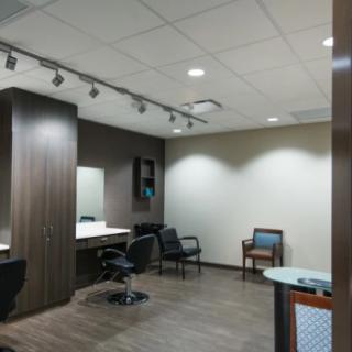 A modern salon interior with chairs, mirrors, and a waiting area.