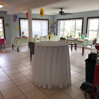 A decorated indoor space set up for a party with tables and balloons.