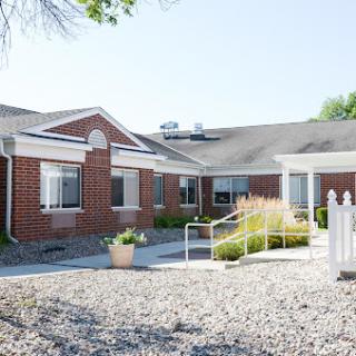 A welcoming single-story brick residential building with well-maintained landscaping.