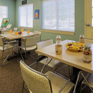 A break room with tables and chairs, featuring snacks and beverages.