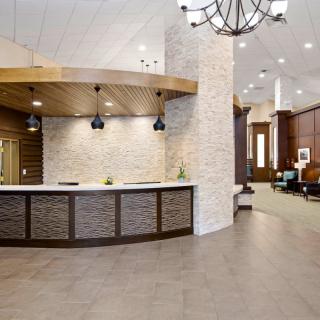 A modern reception area with a curved desk and elegant chandelier lighting.