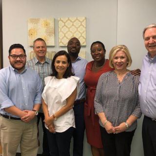 A group of colleagues posing together in an office setting.