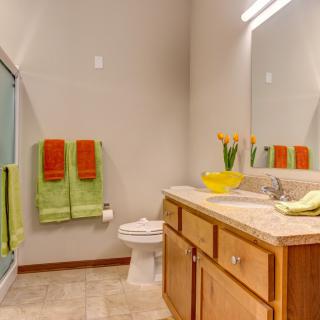 A well-lit bathroom with colorful towels and a modern sink area.