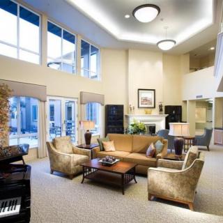A modern and spacious living room with large windows, comfortable seating, and elegant lighting.