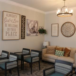 A cozy living room with a sofa, chairs, and decorative wall art.