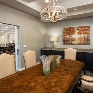 A well-appointed dining room featuring a wooden table, upholstered chairs, and elegant decor.