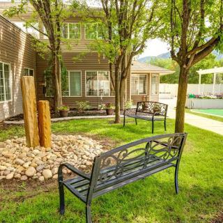 A peaceful garden area featuring benches, trees, and well-maintained landscaping.