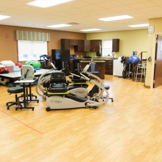 A rehabilitation center with exercise equipment and beds for physical therapy sessions.