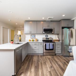 A modern kitchen interior with stainless steel appliances and gray cabinets.