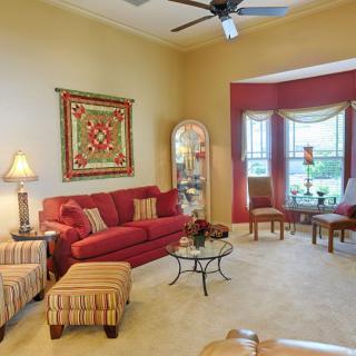 A cozy living room with a red sofa, coffee table, and elegant decor.