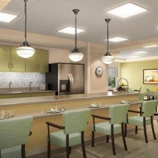 A modern kitchen interior with a long counter and stylish pendant lighting.