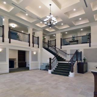A spacious lobby with a grand staircase and elegant chandelier.
