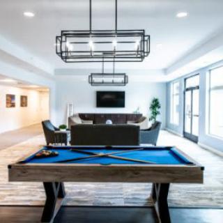 A modern game room featuring a stylish pool table and contemporary seating area.