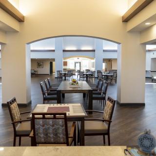 A spacious dining area with neatly arranged tables and chairs, showcasing modern interior design.