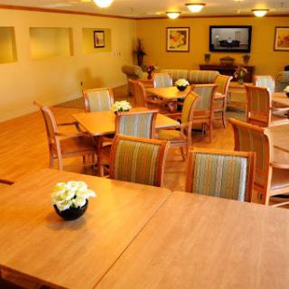 A cozy lounge area featuring wooden tables and chairs, perfect for gatherings or relaxation.