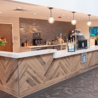 A modern cafe counter with stylish lighting and beverage equipment.