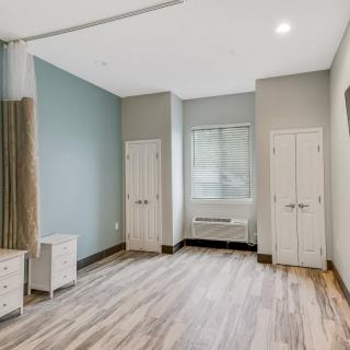 A modern, empty room with wooden flooring and natural light.