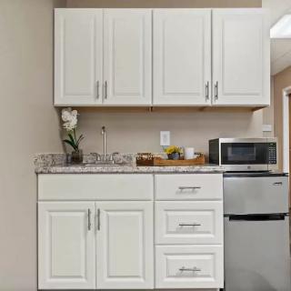 Small kitchen area with white cabinets and appliances.