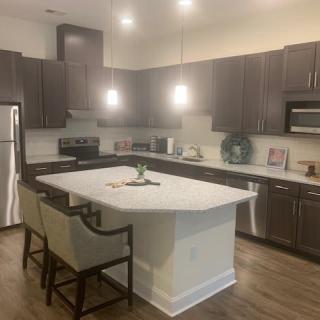 A modern kitchen featuring an island with seating, stainless steel appliances, and sleek cabinets.