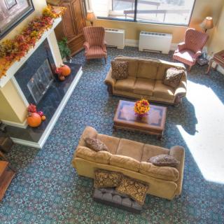 A cozy living room featuring fall decorations, two sofas, and a fireplace, viewed from above.