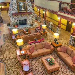 A cozy hotel lobby with comfortable seating and a stone fireplace.