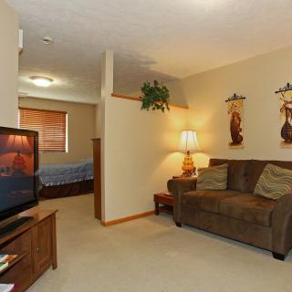 A cozy living room with a sofa, television, and decorative elements.