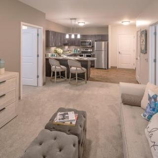 A modern apartment living space featuring an open layout with a cozy seating area and a stylish kitchen.