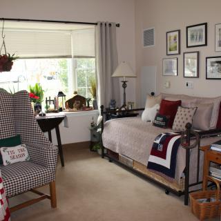 A cozy living room with a large window, comfortable seating, and decorative elements.