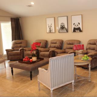 A cozy living room featuring recliner chairs, a coffee table, and wall art for a comfortable setting.