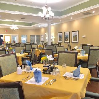 A spacious dining room with neatly arranged tables and chairs, featuring elegant decor and table settings.