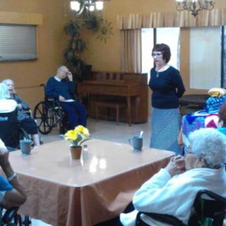 A group of elderly people gathered in a nursing home for a social activity.