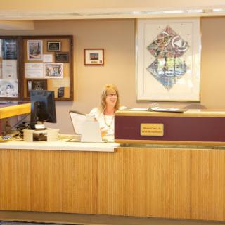 A woman at a reception desk in an office setting.