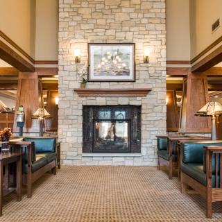 A cozy living room with a central stone fireplace and modern furnishings.