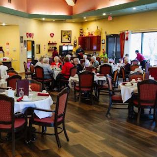 A bustling dining room filled with people enjoying a meal together, showcasing a warm and inviting atmosphere.