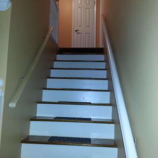 Staircase leading to a closed door at the top of a hallway.