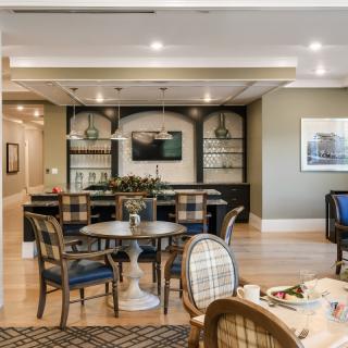 A stylish dining area featuring elegant furniture and a well-lit bar.