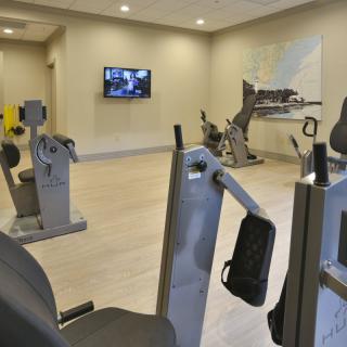 A modern gym with various exercise equipment and cardio machines.