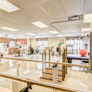 A spacious physical therapy gym equipped with various exercise apparatuses and rehabilitation tools.