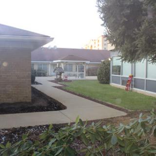 A serene view of a landscaped area featuring pathways and buildings.