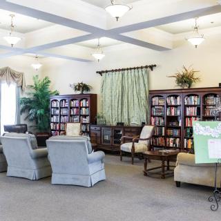 A cozy library room with bookshelves and a comfortable seating area.