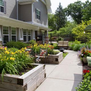 A beautiful garden with raised flower beds and a well-maintained patio area.