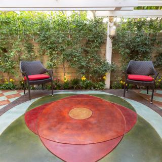 A cozy outdoor patio with two chairs and vibrant greenery.
